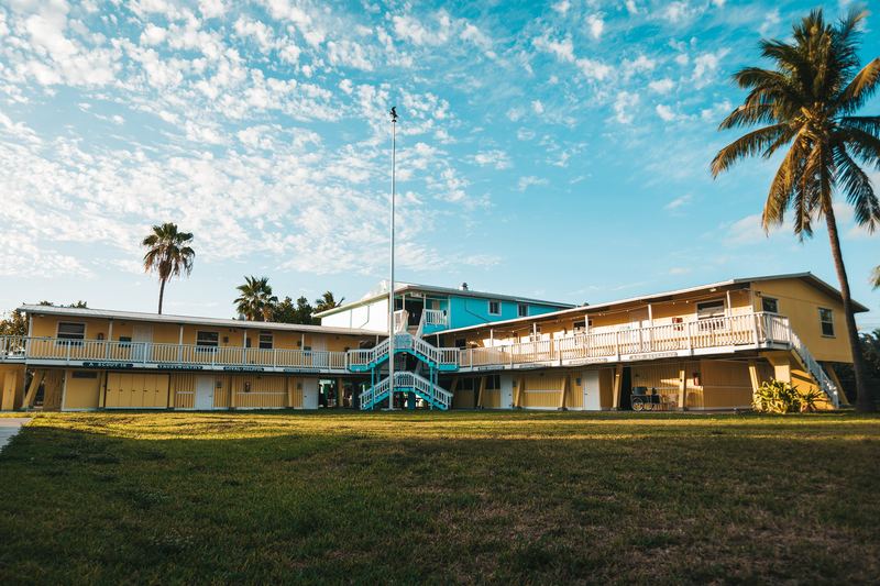 Two-story sailing and scuba dormitories under palm trees at Sea Base in Islamorada, Florida